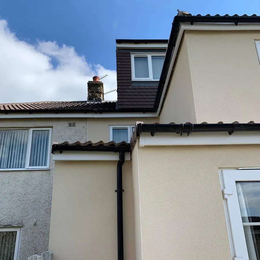 Dark gutters along a rendered terrace roofline
