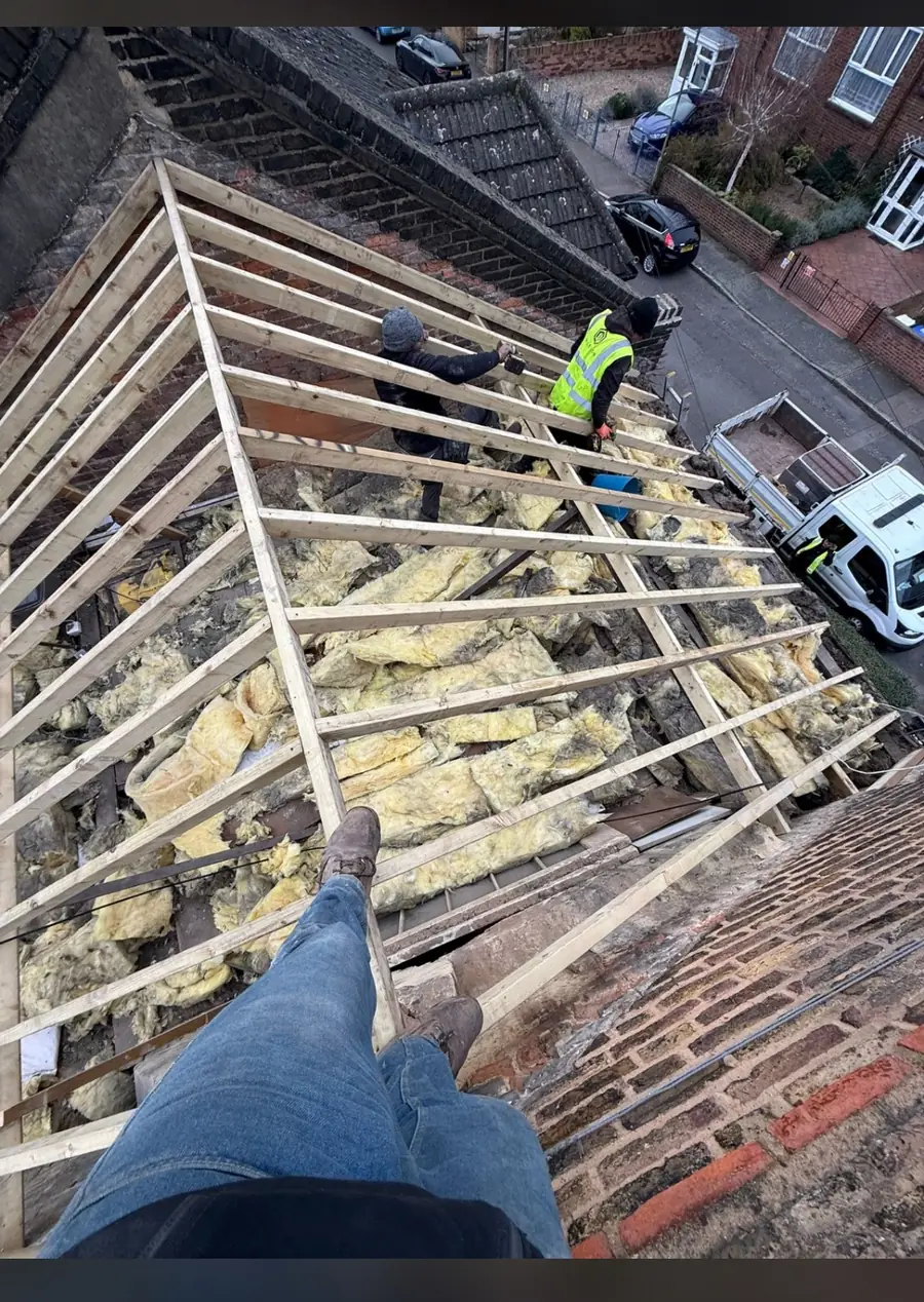 Roof stripped back to the rafters with the loft insulation showing, ready for new membrane